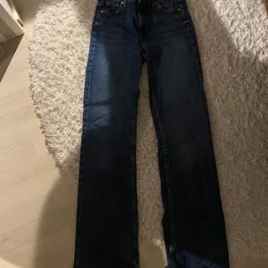 Mörkblå jeansbyxor - Snygga mörkblå jeansbyxor med klassisk design. De har en rak passform och är perfekta för en avslappnad stil. Byxorna har en dragkedja och knappar framtill.