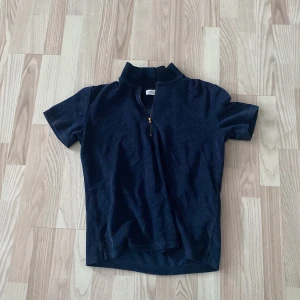 Mörkblå kortärmad tröja från Avenue Tropicale - Mörkblå piké med zip. Perfekt sommar tröja