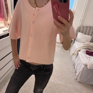 Ljusrosa ribbad kofta🥰🥰 - Säljer en söt ljusrosa kofta med korta ärmar och knappar framtill. Den har en ribbad struktur och en avslappnad passform som gör den perfekt för vår och sommar. SUPER söt 💞💞💞💞