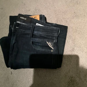 Svarta jeans från Replay - Snygga svarta jeans från Replay med en klassisk design. De har en dragkedja och knapp framtill samt en liten Replay-logga på fickan. Perfekta för en stilren look.