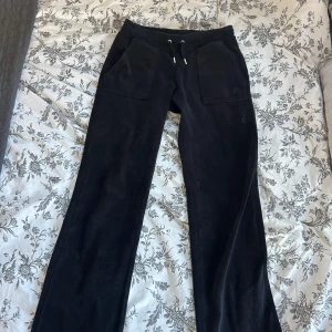 Svarta mjukisbyxor från Juicy Couture - Snygga svarta mjukisbyxor från Juicy Couture med dragsko i midjan och fickor både fram och bak. 