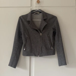 Grå jacka från H&M - Säljer en grå jacka från H&M med dragkedja framtill och två dragkedjeförsedda fickor. 
