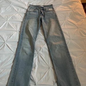 Ljusblå jeans med bootcut - Snygga ljusblå jeans med bootcut-stil. De har en klassisk femficksdesign och är högmidjade för en bekväm passform. Perfekta för en avslappnad look. Samt en slits längst ner på jeansen