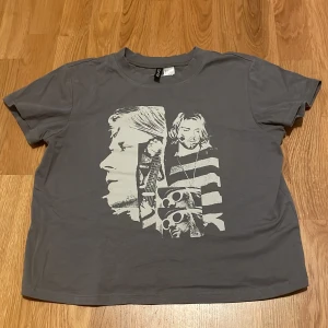 Grå t-shirt med tryck - säljer en grå t shirt med kurt cobain tryck på, den är ifrån Hm och använd 1 eller 2 ggr. 🙂‍↕️OBS: uppe vid nacken så finns det som små jack, men den är inte sliten utan jag tror det bara är för looken eftersom den såg ut så när jag köpte den i butik 💞storlek: S