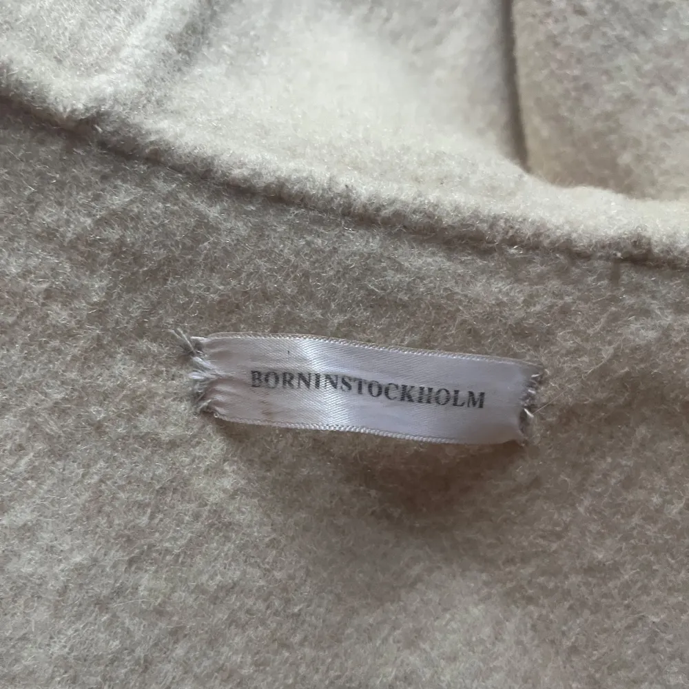 Säljer en elegant beige kappa från Born in Stockholm. Den har en stor huva med fluffig pälsdetalj och ett knytbälte i midjan. Perfekt för kyliga dagar när du vill hålla stilen. 🧥✨ jätte bra skick och inga skavanker som jag kan se. Endast använd några få gånger. Storlek S men passar mellan xs-m skulle jag säga. 50% ull och 50% cashmere. nypris runt 4500kr. Skriv om du har några frågor💕pris går att diskutera vid snabb handel☺️. Takit.