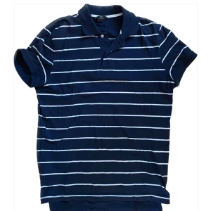 Mörkblå randig pikétröja - Snygg mörkblå pikétröja med vita ränder. Inte använd mycket då den är något stor på mig. Bra skick. Skriv vid intresse eller fundering, pris kan diskuteras vid snabb affär.