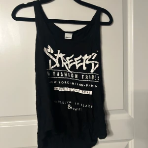 Svart linne med tryck - Coolt svart linne med vitt tryck från Gina tricot. Perfekt för en avslappnad stil. Linnet har en lös passform och ärmlös design, vilket gör det bekvämt och luftigt.