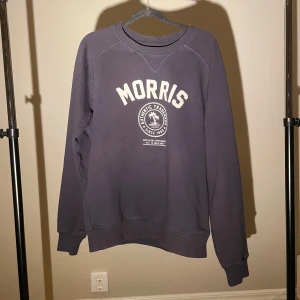 Mörkblå sweatshirt från Morris - Säljer en snygg mörkblå sweatshirt från Morris med tryck framtill. Tröjan har långa ärmar och en rund halsringning. Perfekt för en avslappnad stil. 🌀