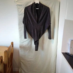 Svart glittrig kofta - Säljer en superfin svart body med glittriga ränder. Den har långa ärmar.. Perfekt för att glamma upp vilken outfit som helst! 🖤✨