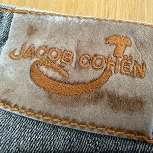 Jacob Cohen  - Premiumjeans i toppkvalitet. Handsydda i Italien av japanskt denimtyg. Horsehide logo patch. Tvättade några gånger. Vissa mindre nötningar, men fräscha och hela. Nypris runt 5000.  Märkta W34, men små i storleken. 
