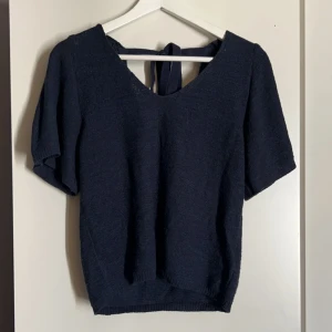 Stickad tröja  - Säljer denna trekvarts ärmade tröja som man knyter vid nacken för att den bara används ett fåtal gånger! Är L men sitter även bra på M