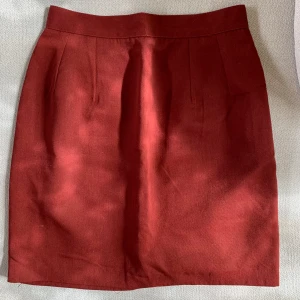 Vinröd kortisol Grafity’s Paris - En mörkröd kjol från Grafity’s Paris köpt på vintage-affär med en knapp och dragkedja i ryggen. Kjolen är fållad med texilklister (de sista bilden) och har en innekjol i silkigt material. Midjemått 67 cm och längd 45 cm.