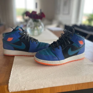 Nike air Jordan 1 Racer Blue (GS)  - Nike air Jordan skor i färgkombinationen ”Racer Blue” som är väldigt unik och svår att få tag på!   Sjukt snygga och sparsamt använda!   Dessa är även i ”mid” höjd och är storlek 39!  