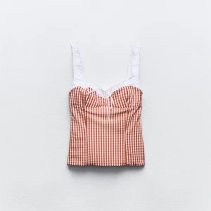 Topp från Zara i storlek xs - Säljer denna trendiga topp från zara i storlek xs🩷 Toppen är röd/vit rutig och har knytning vid bysten samt en fyrkantig urringning. Det är dragkedjor på båda sidorna