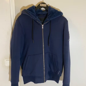 Moose knuckle Bunny, mörk blå.  - Väldigt fräsch, tagit hand om den väldigt bra. Har ej använt den så mycket på grund av att jag har en annan jacka. Går ej att hitta denna färg hos nk Nypris: 4,600kr på nk   Kvitto finns på begäran.  Ej fastpris!! Går att buda!! 