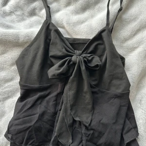 Linne med Knut stl S - Svart linne med tunna band. Storlek S. Knut framtill. Aldrig använd, inga defekter. 