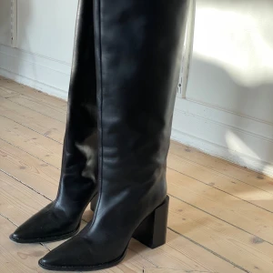 COS Stövlar  - https://www.cos.com/en_sek/women/accessories/shoes/boots/product.knee-high-pointed-leather-boots-black.1120206001.html  modern knee-high boots crafted from shiny chrome-free leather. They feature pointed toes, comfortable tonal block heels and a cent