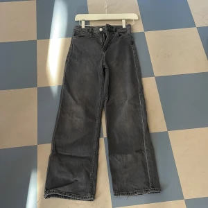 Gråa wide leg jeans - Säljer ett par gråa wide leg jeans i storlek 146. De är högmidjade och har en avslappnad passform som är perfekt för en cool och bekväm stil. Jeansen är i denim. 