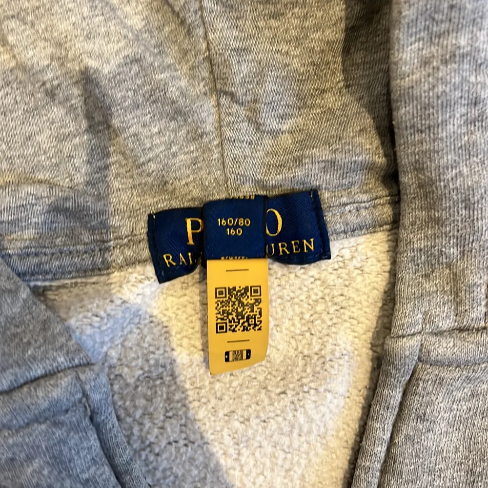 Säljer en snygg och bekväm grå hoodie från Ralph Lauren. Den har en dragkedja framtill och en klassisk logga broderad på bröstet. Perfekt för både vardag och chill. Den är i bra skick och supermjuk inuti. Passar perfekt för höst och vår! . Tröjor & Koftor.