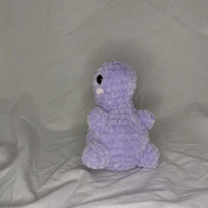 Virkad dino - Höjd: 13cm Bred: 10cm Det är en egenvirkad dino som är gjord på fluffigt garn som är 100% polyester 