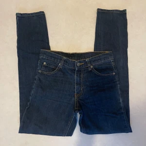 Mörkblå jeans från Cheap Monday - Snygga mörkblå jeans från Cheap Monday med klassisk femficksdesign och guldfärgade sömmar. Perfekta för en avslappnad stil. Märkeslogga på baksidan.