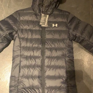 Svart Under Armour jacka  - Under Armour jacka i storlek S som kom idag men va för liten eftersom jag gått upp i vikt. Helt ny, test jackan endast 1 gång men annars är den som sprillans ny. Ordinarie pris på jackan är 2499kr men sänker givetvis priset här eftersom ni annars hade valt att beställa från deras hemsida.
