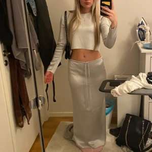 Satin set från Zara - Elegant långkjol med snörning i midjan. Perfekt för en stilren look. Tillsammans med långärmad matchande topp. Båda i satin
