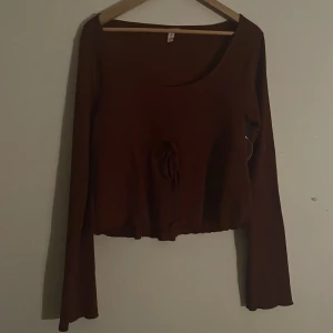 Vinröd topp med knyt från Nelly - Säljer en vinröd topp från Nelly med ❤️prislapp kvar❤️knytning i midjan. Toppen har långa ärmar och en rund halsringning. Perfekt för en stilren look.
