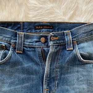 Nudie jeans, slim Jim - Nudie jeans i riktigt bra skick. Riktigt skön tvätt med den ikoniska bakficka mönstret. Storlek 31,32 men sitter mer som 30,32.  Hör av dig vid frågor eller funderingar. MVH. Båstad pluggen.
