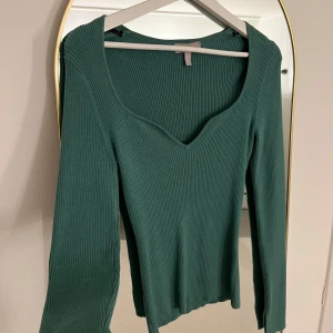 Grön ribbad tröja - Snygg grön ribbad tröja med v-ringning och långa ärmar. Perfekt för en stilren look.