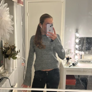 Grå stickad tröja från H&M - Säljer en mysig grå stickad tröja från H&M. Tröjan har långa ärmar och en klassisk rund halsringning. Perfekt för kyligare dagar och enkel att matcha med olika outfits. Köpt för 200kr och använd ett fåtal gånger. Säljer pågrund av att den inte kommer till användning🩶💐