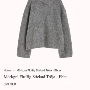 Mörkgrå Fluffig Stickad Tröja - Ebba - Säljer en mörkgrå fluffig stickad tröja från Design by Amor. Tröjan har en mysig och varm känsla, perfekt för kyligare dagar. Den har en enkel design med långa ärmar och en lös passform. Aldrig använts och är helt ny. Original priset är 399 och säljer för 299
