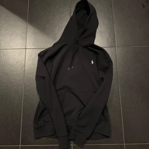 Polo ralph lauren hoodie - Snygg svart hoodie från Ralph Lauren med klassisk logga på bröstet. Perfekt för en avslappnad stil med justerbar huva och ribbade muddar. Ett måste i garderoben för alla hoodie-älskare! Knappt använd så Skick:9,5/10. Nypris: runt 1800kr. Priset är ej hugget i sten. Fråga om det är något.