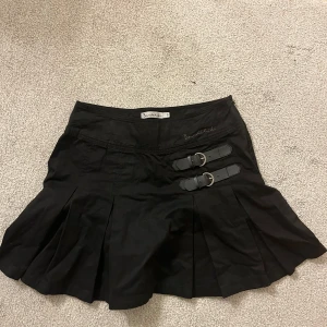 Svart kjol Bondelid - Snygg svart kort kjol från Bondelid med spännen på sidan. Superbra skick