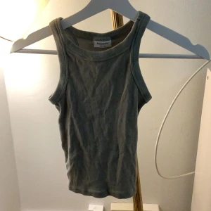 Grå ribbad linnetopp från Kappahl - Säljer en grå ribbad linnetopp från Kappahl. Toppen är ärmlös och har en klassisk rund halsringning. Perfekt för varma dagar eller som lager under en tröja.