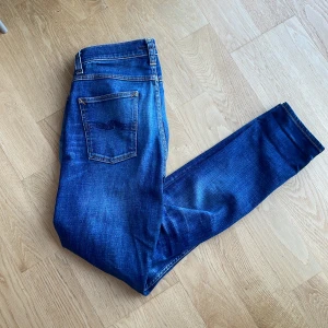 Blåa Nudie Jeans - Säljer nu dessa blåa jeans från Nudie. Midjan är normal och passformen är slim! W30 L34