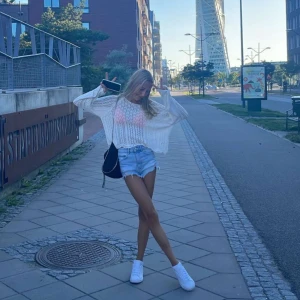 Vit stickad tröja - Säljer en luftig vit stickad tröja med lång ärm och en avslappnad passform. Perfekt för en somrig dag eller en sval kväll. Tröjan har en transparent look som ger en trendig stil.