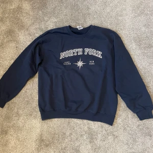 Mörkblå collegetröja  - Säljer en mörkblå sweatshirt från Gildan med texten 'North Fork' tryckt på framsidan. Köpt second hand men fint skick. 