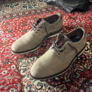 Beige skor från Bull Boxer - Snygga beige skor från Bull Boxer med snörning och en stilren design. Tillverkade i Portugal, dessa skor har en robust sula och är perfekta för både vardag och mer formella tillfällen.