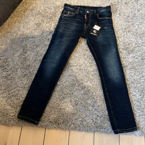 Mörkblå jeans från Dsquared2 - Snygga mörkblå jeans från Dsquared2 med en skaterstil. De har en klassisk femficksdesign och tydliga sömmar. Perfekta för en cool och avslappnad look. Storleken passar 12y. Dem är helt nya!