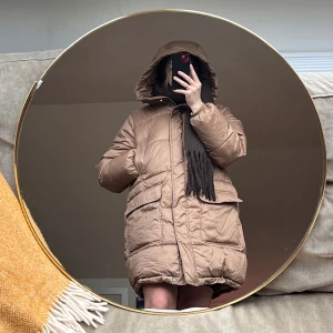 Beige pufferjacka med huva - Säljer en mysig beige pufferjacka med huva. Jackan har en oversized passform och praktiska fickor framtill. Perfekt för kyliga dagar.