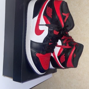 Nike Air Jordan 1 Mid i svart, röd och vit - Pris kan diskuteras!!!Säljer ett par Nike Air Jordan 1 Mid i klassiska färgerna svart, röd och vit. Skorna har en snygg design med snörning och den ikoniska Air Jordan-loggan på sidan. Perfekta för både vardag och fest. De är i mycket bra skick och kommer i originalkartong. Inte använda.