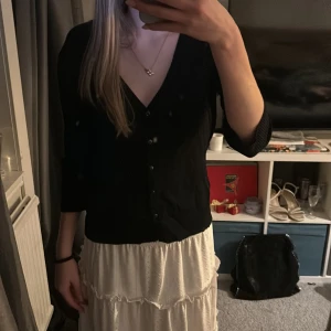 Svart kofta  - En stilren svart kofta med v-ringning och knappar framtill. Perfekt för en chic och avslappnad look. skriv för mer information💕