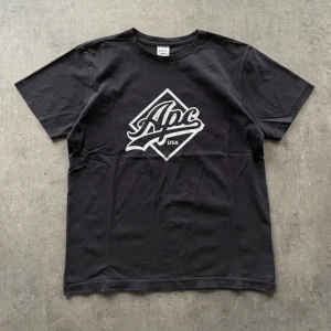 APC USA T-shirt - En APC t-shirt i svart färg med tryck. Tröjan är storlek M och passar true to size utan skador eller defekter. Känn dig fri att fråga om du undrar något! 
