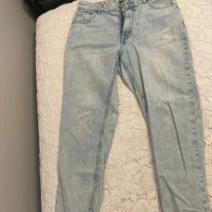 Ljusblå jeans från FB Sister - Säljer ett par ljusblå jeans från FB Sister i storlek XL. De har en klassisk femficksdesign och en bekväm passform. Jeansen har en sliten look med små revor för en trendig stil. Perfekta för vardagsbruk och kan matchas med nästan vad som helst!