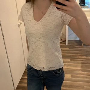 Vit spetsblus - Säljer en söt vit spetsblus med korta ärmar och v-ringning. 