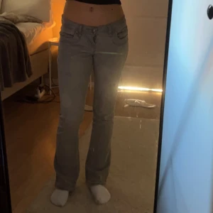 Grå jeans med bootcut - Säljer ett par lågmidjade bootcut jeans. De är uppsprättade och var från början L30, men nu är de L 32. W25. Skitsnygga! Använd fåtal gånger då de egentligen inte är min stil🤗  