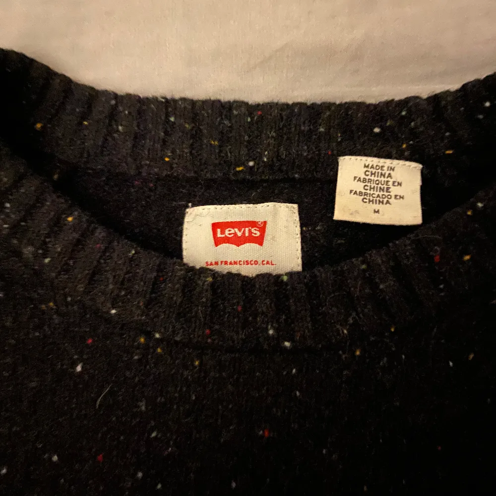 Säljer en snygg svart stickad tröja från Levi's i storlek M (passar även S bra då den är lite åt de tightare hållet). Tröjan har ett diskret mönster med små färgprickar och är perfekt för både höst och vinter.  Jättesnygg och prisvärd. Nypris ligger runt 800-900kr. Tröjor & Koftor.