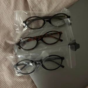 Tre par glasögon i olika stilar - Säljer tre par glasögon med rundade bågar. Ett par är i svart, ett i leopardmönster och ett i brunt . Perfekta för att variera din stil!