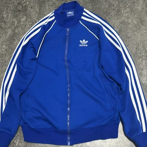 Adidas Zip - Jag säljer en blå Adidas zip. Den är enavänd ett par gånger men den är perfekt skick inga skador. Nypris 600kr. priset kan diskuteras! 